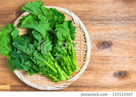 A bunch of rape blossoms arranged on a bamboo basket. Spring vegetable ingredients A bunch of rape blossoms arranged on a bamboo basket. Spring vegetable ingredients 135533507