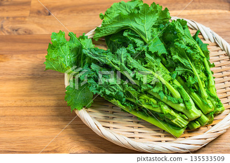 A bunch of rape blossoms arranged on a bamboo basket. Spring vegetable ingredients A bunch of rape blossoms arranged on a bamboo basket. Spring vegetable ingredients 135533509