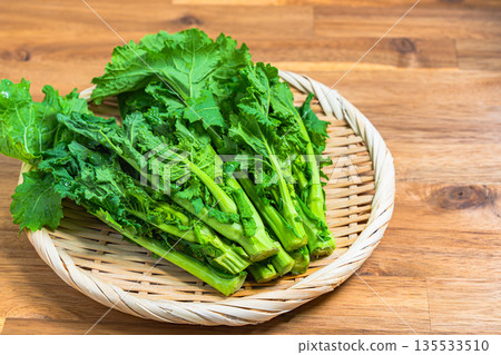 A bunch of rape blossoms arranged on a bamboo basket. Spring vegetable ingredients A bunch of rape blossoms arranged on a bamboo basket. Spring vegetable ingredients 135533510