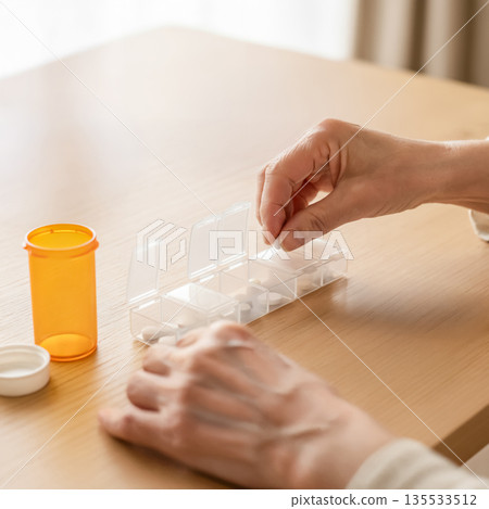 Sorting medicines in a pill case. Medication management habits. 135533512