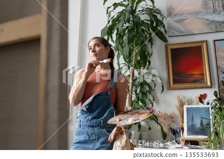Talented artist female painter thinking looking at picture, creative inspirational working process. 135533693