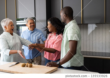 Three generations in kitchen preparing meal, sharing laughter and joyful moments Three generations in kitchen preparing meal, sharing laughter and joyful moments 135533926