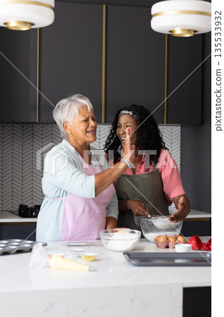 Baking together, grandmother and child in modern kitchen, sharing joyful moment Baking together, grandmother and child in modern kitchen, sharing joyful moment 135533932