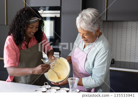 In kitchen, grandmother and child baking together, sharing joyful moments and smiles In kitchen, grandmother and child baking together, sharing joyful moments and smiles 135533941