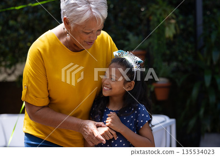 Grandmother and granddaughter sharing joyful moment outdoors, both smiling warmly Grandmother and granddaughter sharing joyful moment outdoors, both smiling warmly 135534023