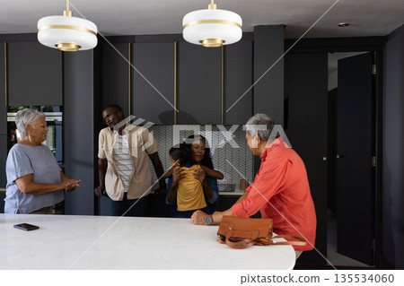 African American family enjoying time together in modern kitchen, sharing laughter African American family enjoying time together in modern kitchen, sharing laughter 135534060