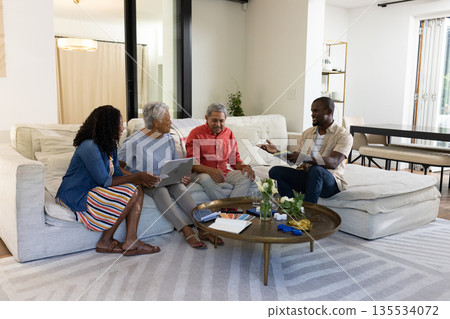 Family in living room using digital devices and having conversation together 135534072
