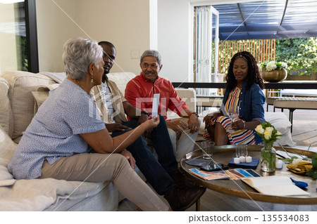 Family sharing memories and having conversation in cozy living room together Family sharing memories and having conversation in cozy living room together 135534083
