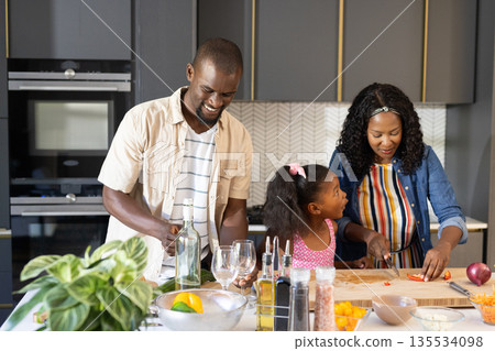 Cooking together in modern kitchen, African American family smiling and bonding 135534098