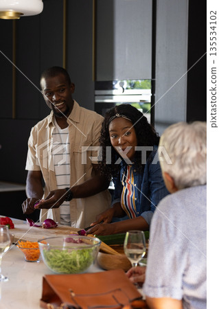 Cooking together, family sharing laughter and conversation in modern kitchen 135534102
