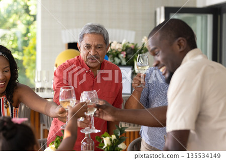 Family celebrating together, clinking glasses and sharing joyful moments at home 135534149