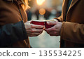 Two people share coffee cups on a street, embodying compassion and friendship in a moment of kindness 135534225