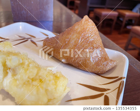 Inari sushi is a Japanese dish consisting of sweet, simmered fried tofu stuffed with vinegared rice. Inari sushi is a Japanese dish consisting of sweet, simmered fried tofu stuffed with vinegared rice. 135534355