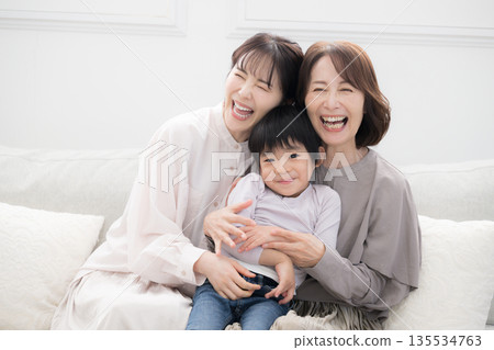 一張溫馨的三代同堂家庭紀念照,祖母、母親和孩子麵帶微笑,互相擁抱。 一張溫馨的三代同堂家庭紀念照,祖母、母親和孩子麵帶微笑,互相擁抱。 135534763