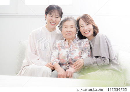 一張溫馨的三代同堂家庭紀念照，祖母、母親和孩子麵帶微笑，互相擁抱。 135534765