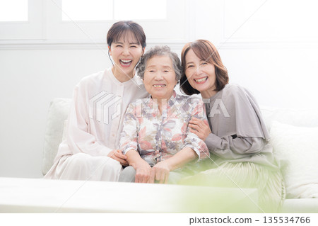 A happy commemorative photo of a three-generation family, with grandmother, mother and child smiling and embracing each other 135534766