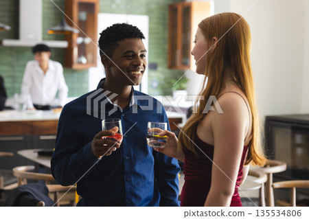 Teenagers having conversation and drinks at home during celebration 135534806