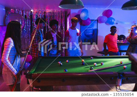 Teenagers playing pool at lively party, enjoying vibrant celebration with friends Teenagers playing pool at lively party, enjoying vibrant celebration with friends 135535054