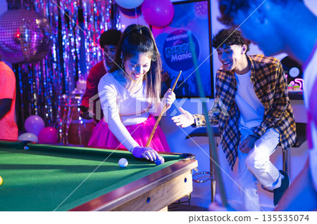 Teenagers playing pool at party, enjoying vibrant celebration with friends Teenagers playing pool at party, enjoying vibrant celebration with friends 135535074