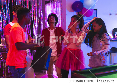 Teenagers laughing and celebrating at home with balloons and party decorations Teenagers laughing and celebrating at home with balloons and party decorations 135535076