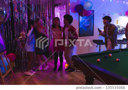 Teenagers celebrating at home, enjoying party with music and colorful decorations 135535088