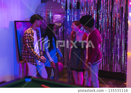 Teenagers enjoying party with friends, laughing near disco ball and decorations Teenagers enjoying party with friends, laughing near disco ball and decorations 135535116