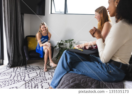 Teen girls enjoying conversation and laughter together in cozy living room Teen girls enjoying conversation and laughter together in cozy living room 135535173