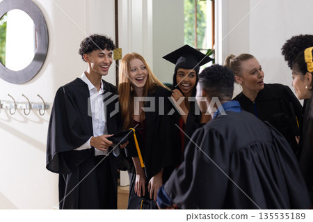 Teen graduates in caps and gowns celebrating together with joyful expressions Teen graduates in caps and gowns celebrating together with joyful expressions 135535189
