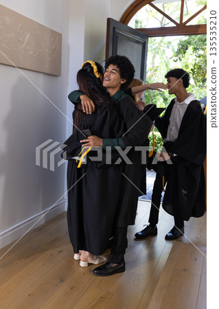 In school hallway, graduating students hugging, celebrating their success together In school hallway, graduating students hugging, celebrating their success together 135535210