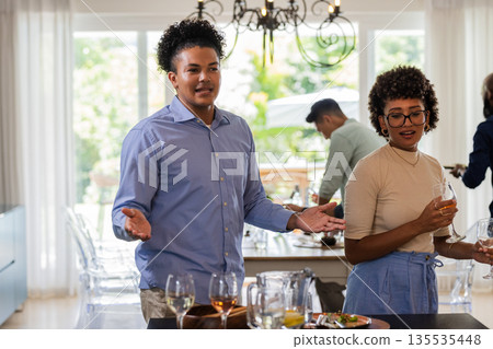 African American couple enjoying drinks and conversation at elegant indoor gathering African American couple enjoying drinks and conversation at elegant indoor gathering 135535448