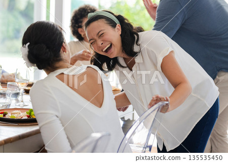 Guests laughing and enjoying conversation at wedding reception, celebrating together Guests laughing and enjoying conversation at wedding reception, celebrating together 135535450