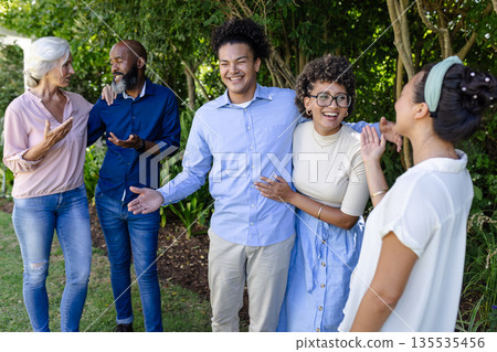 Friends and family celebrating outdoors, sharing joyful moments at wedding event Friends and family celebrating outdoors, sharing joyful moments at wedding event 135535456