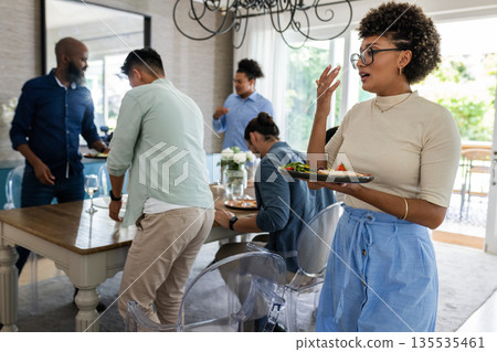 Guests enjoying lively conversation and delicious food at wedding celebration 135535461