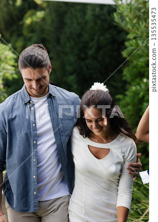 Walking together, couple celebrating wedding outdoors, smiling and sharing happiness Walking together, couple celebrating wedding outdoors, smiling and sharing happiness 135535473