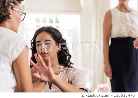 Bride getting ready, bridesmaid helping with jewelry, focused and attentive Bride getting ready, bridesmaid helping with jewelry, focused and attentive 135535476