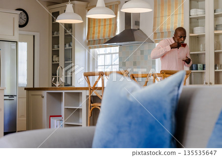 African American man enjoying meal in modern kitchen, standing by counter African American man enjoying meal in modern kitchen, standing by counter 135535647