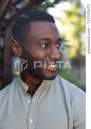 Smiling African American man enjoying outdoor time, looking away with happiness 135535675