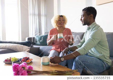 African American friends having coffee and chatting in cozy living room African American friends having coffee and chatting in cozy living room 135535735