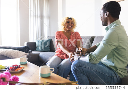 African American friends laughing and enjoying coffee together in cozy living room African American friends laughing and enjoying coffee together in cozy living room 135535744