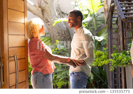 Couple holding hands and smiling, enjoying sunny day in lush garden 135535773
