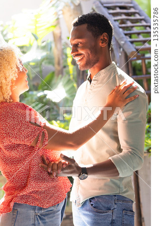 Smiling friends enjoying conversation and laughter outdoors in sunny garden setting Smiling friends enjoying conversation and laughter outdoors in sunny garden setting 135535786