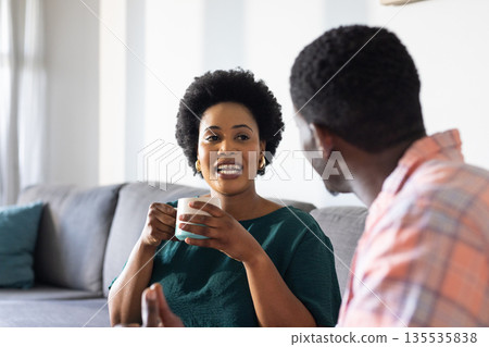 Friends enjoying coffee and conversation at home, sharing laughter and stories Friends enjoying coffee and conversation at home, sharing laughter and stories 135535838