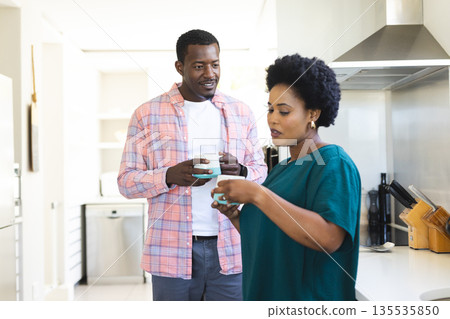 African American friends enjoying coffee and conversation in modern kitchen 135535850