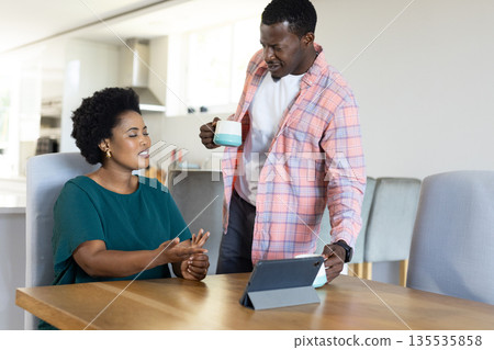 Discussing project, African American friends using tablet and drinking coffee at home 135535858