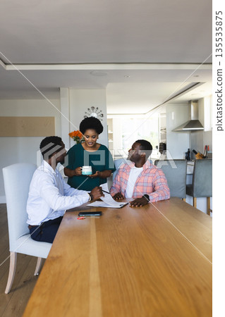 African American friends having coffee and chatting at home around dining table African American friends having coffee and chatting at home around dining table 135535875