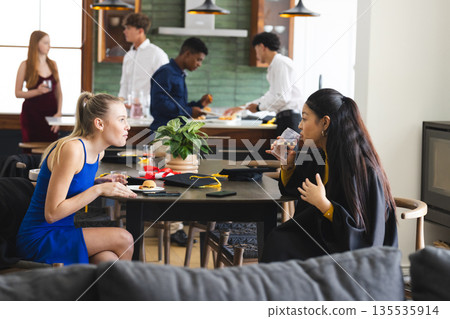 Teens enjoying lively conversation and snacks at home during celebration gathering 135535914