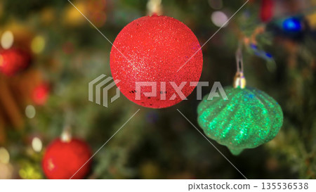 festive arrangement of glittering colorful Christmas ornament balls nestled in lush evergreen branches, creating a warm, celebratory mood perfect for holiday decor and seasonal stock photography festive arrangement of glittering colorful Christmas ornament balls nestled in lush evergreen branches, creating a warm, celebratory mood perfect for holiday decor and seasonal stock photography 135536538