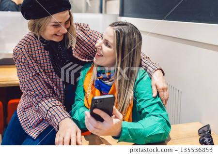 Two beautiful women met in cafe and looked at messages on their phones 135536853