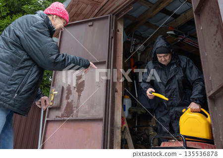 Two men starting generator in winter garage 135536878