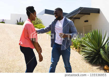Couple enjoying outdoor conversation, smiling and embracing in sunny garden setting Couple enjoying outdoor conversation, smiling and embracing in sunny garden setting 135536955